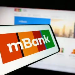 Logo mBank na ekranie telefonu. Dowiedz się, jak spłacić wcześniej kredyt w mBanku, korzystając z aplikacji mobilnej lub bankowości internetowej.