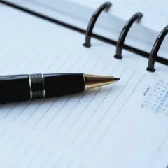 Czarny długopis na kalendarzu. Planowanie działań, jak usunąć zapytania w BIK, wymaga systematyczności.
