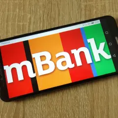 Smartfon z logo mBank na kolorowym tle. Dowiedz się, jak aktywować kartę mBank, korzystając z aplikacji mobilnej.
