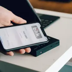 Dłoń trzyma smartfon z aplikacją Blik. Dowiedz się, jak zmienić limit Blik w Millenium, by bezpiecznie zarządzać finansami.