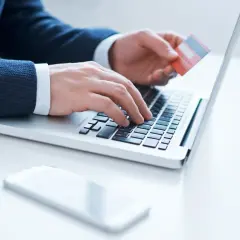 Mężczyzna wpisuje dane karty Millenium na laptopie, przygotowując się do aktywacji.