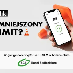 Ręka trzyma smartfon z potwierdzeniem wypłaty BLIKIEM. Obok pomarańczowe pachołki. Zwiększ limit wypłat BLIKIEM w bankomatach SGB.