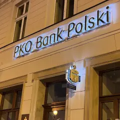 Jasny neon "PKO Bank Polski" nad wejściem. Sprawdź, kiedy nowe lokaty w PKO BP, by pomnożyć oszczędności.