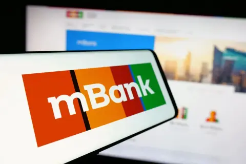 Logo mBank na ekranie telefonu. Dowiedz się, jak spłacić wcześniej kredyt w mBanku, korzystając z aplikacji mobilnej lub bankowości internetowej.