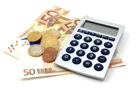 Euro to waluta w Niemczech. Na zdjęciu banknoty 50 euro, monety i kalkulator.