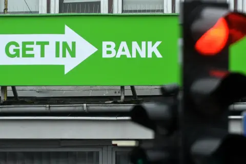Zielony baner z napisem "GET IN BANK" i strzałką. Zastanawiasz się, co z lokatami w Getin Banku?
