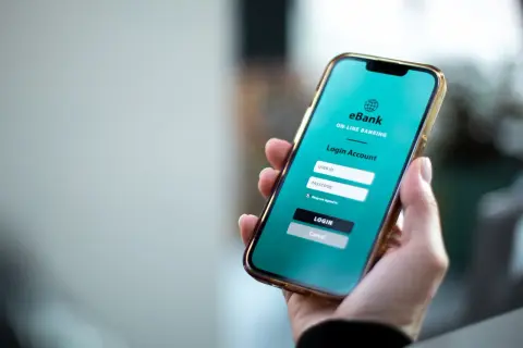 Dłoń trzyma smartfon z ekranem logowania do bankowości internetowej eBank. To wygodny sposób na przychodzące PKO BP.