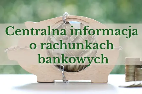 Drewniana skarbonka w kształcie świnki wypełniona monetami, z napisem "Centralna informacja o rachunkach bankowych".