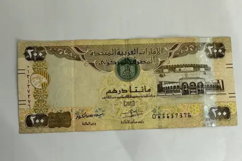 Banknot 200 dirhamów, czyli waluta w Dubaju. Widoczny orzeł i budynek.