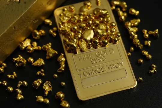 Złote samorodki i sztabka "FINE GOLD 9999 1 OUNCE TROY" - inspiracja, jak inwestować w złoto.