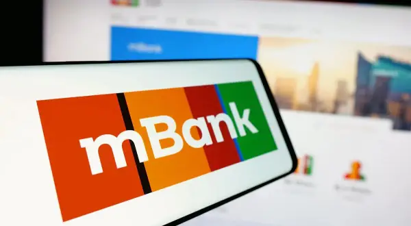 Logo mBank na ekranie telefonu. Dowiedz się, jak spłacić wcześniej kredyt w mBanku, korzystając z aplikacji mobilnej lub bankowości internetowej.