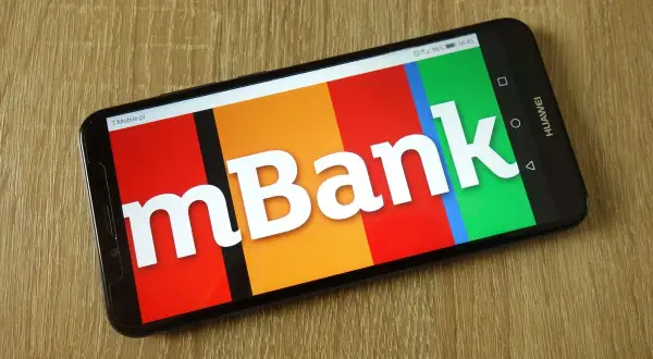 Smartfon z logo mBank na kolorowym tle. Dowiedz się, jak aktywować kartę mBank, korzystając z aplikacji mobilnej.