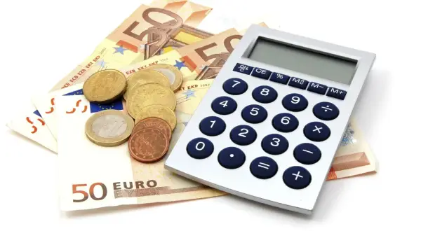 Euro to waluta w Niemczech. Na zdjęciu banknoty 50 euro, monety i kalkulator.
