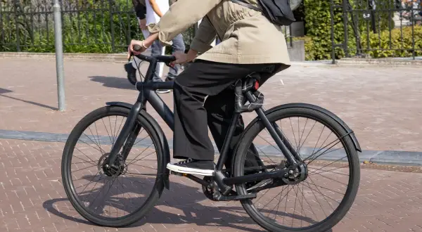 Osoba na czarnym rowerze elektrycznym, korzystająca z dofinansowania do roweru elektrycznego dla kogoś, kto ceni ekologiczny transport.