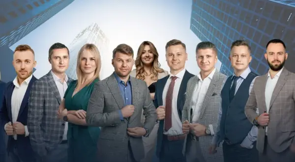 Grupa profesjonalistów w garniturach na tle nowoczesnych budynków.
