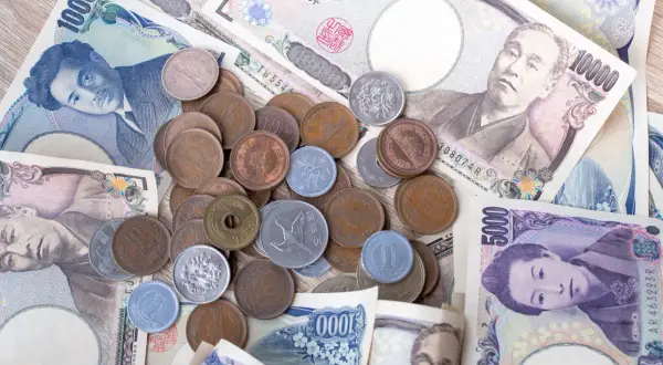Japońskie banknoty i monety, w tym banknot 1000 jenów. Jaka jest waluta w Japonii? Jen.