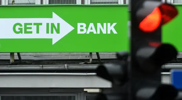 Zielony baner z napisem "GET IN BANK" i strzałką. Zastanawiasz się, co z lokatami w Getin Banku?