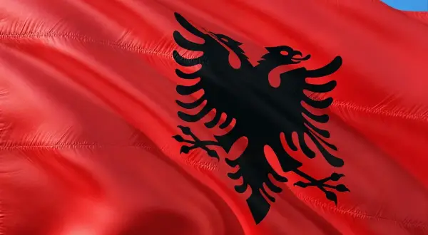 Czerwona flaga Albanii z czarnym dwugłowym orłem. W Albanii obowiązuje waluta lek.