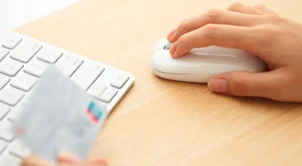 Dłoń trzyma kartę płatniczą przy klawiaturze, gotowa do transakcji online. Może to być początek procesu chargeback Santander.