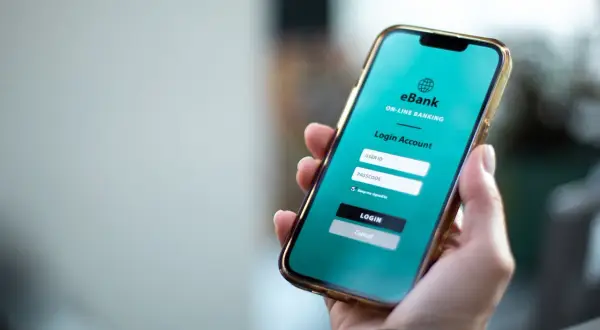 Dłoń trzyma smartfon z ekranem logowania do bankowości internetowej eBank. To wygodny sposób na przychodzące PKO BP.
