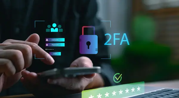 Dłoń loguje się do systemu, widoczny symbol kłódki i napis 2FA co to, podkreślający bezpieczeństwo.