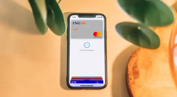 Telefon z kartą ING i napisem "Hold Near Reader" pokazuje, jak płacić Apple Pay. Szybko i bezpiecznie.