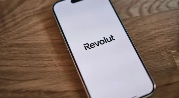 Telefon z logo Revolut na ekranie. Planujesz podróż i szukasz revolut bankomaty bez prowizji?