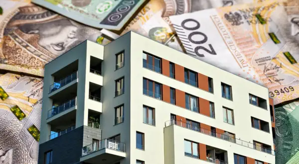 Nowoczesny budynek mieszkalny na tle polskich banknotów. Zastanawiasz się, ile obecnie wynosi oprocentowanie kredytu hipotecznego?