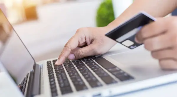 Osoba wpisuje dane karty płatniczej na laptopie, realizując przelewy przychodzące BNP Paribas.
