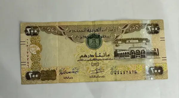 Banknot 200 dirhamów, czyli waluta w Dubaju. Widoczny orzeł i budynek.