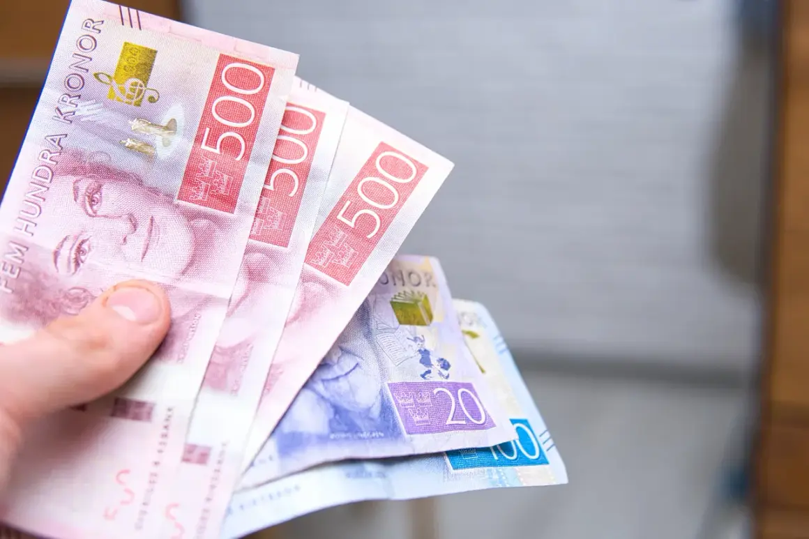 Dłoń trzyma kilka banknotów szwedzkich koron, w tym 500-koronowe.