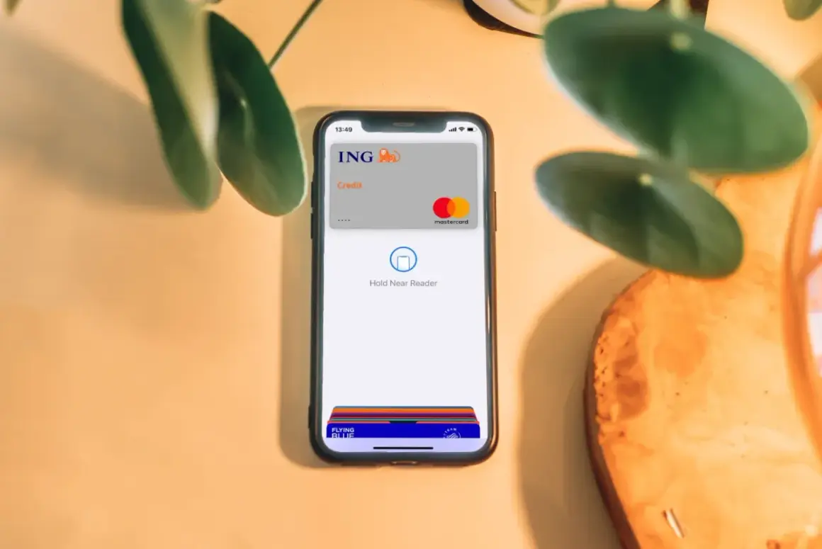 Telefon z kartą ING i napisem "Hold Near Reader" pokazuje, jak płacić Apple Pay. Szybko i bezpiecznie.