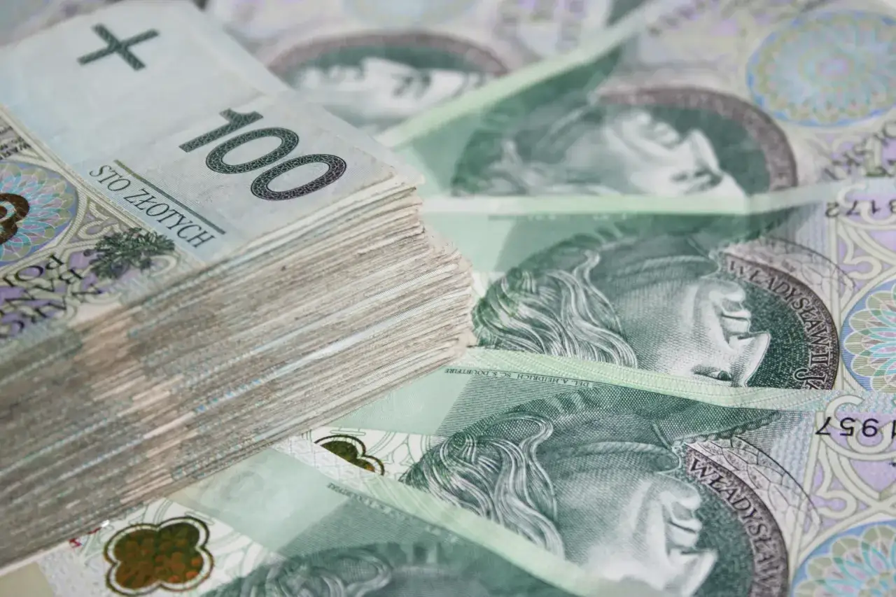 Stos banknotów 100 zł. Zastanawiasz się, ile trzeba byc bezrobotnym zeby dostac dofinansowanie?