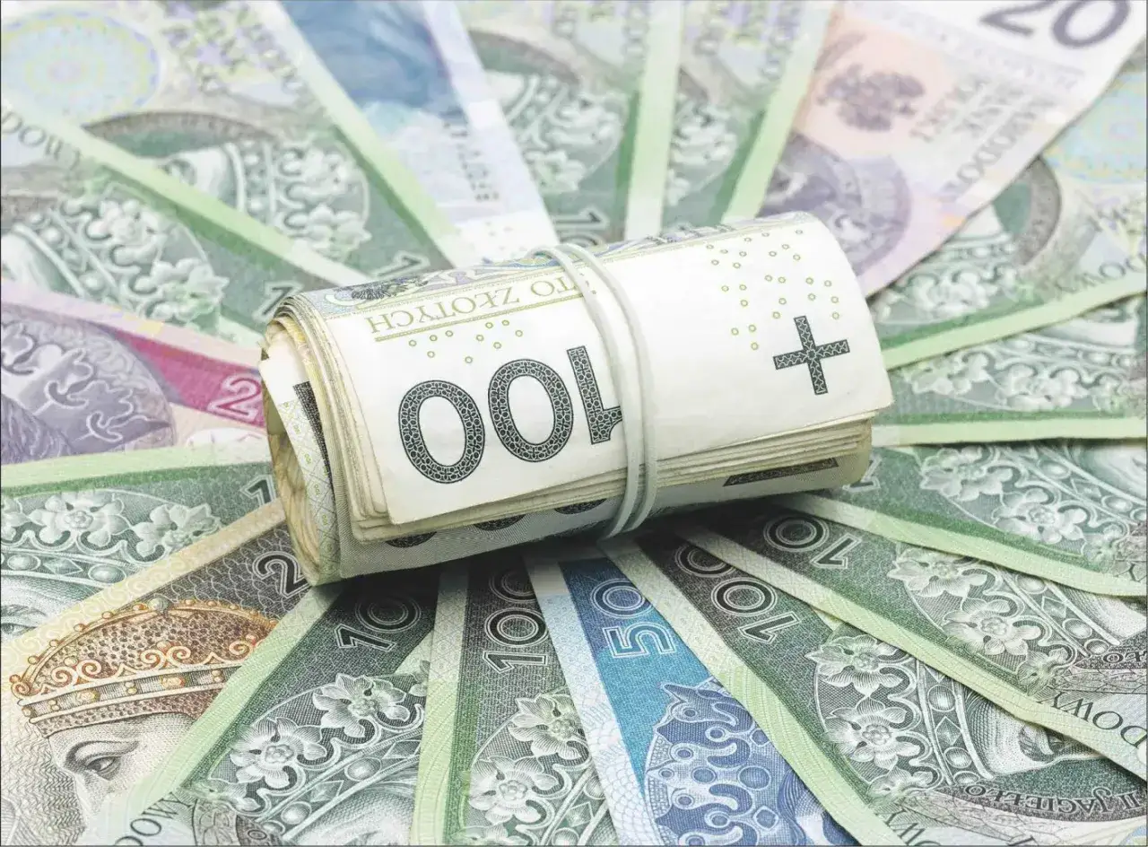 Zwijana paczka banknotów 100 zł na tle innych polskich banknotów. To pokazuje, że bankowy fundusz gwarancyjny co to, chroni Twoje oszczędności.