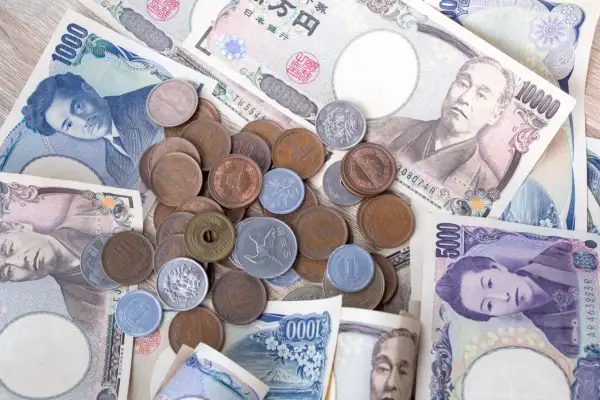 Japońskie banknoty i monety, w tym banknot 1000 jenów. Jaka jest waluta w Japonii? Jen.