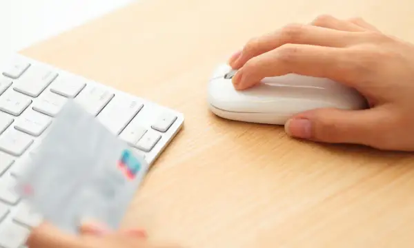 Dłoń trzyma kartę płatniczą przy klawiaturze, gotowa do transakcji online. Może to być początek procesu chargeback Santander.