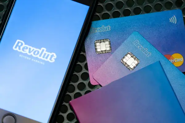 Telefon z logo Revolut i karty płatnicze. Możliwość płatności Revolut Pay Later ułatwia zakupy.