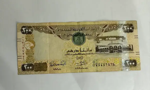 Banknot 200 dirhamów, czyli waluta w Dubaju. Widoczny orzeł i budynek.